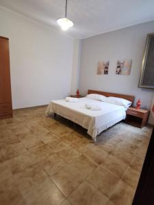 a bedroom with a white bed and a tile floor at Appartamento in centro in Lampedusa