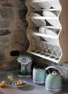 a kitchen counter with plates and glasses on a shelf at Onos Eco Living in Mési