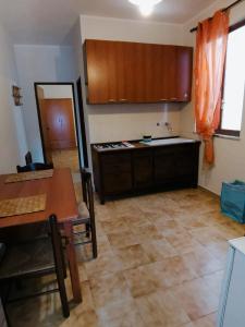 a kitchen with a table and a dining room at Appartamento in centro in Lampedusa