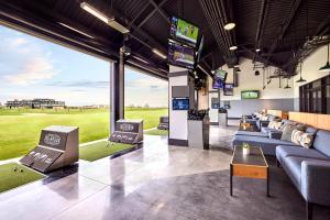 um clube com sofás e televisões e um campo de golfe em Omni PGA Resort Frisco-Dallas em Frisco