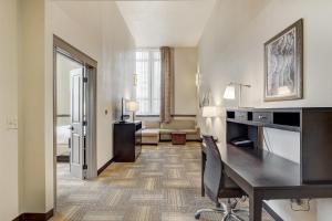 a hotel room with a desk and a living room at Staybridge Suites Baltimore - Inner Harbor by IHG in Baltimore