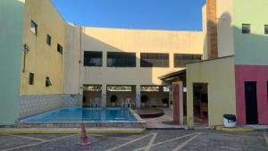 an empty building with a swimming pool in a courtyard at Flat Crystal Park Porto das Dunas- Cristal park in Aquiraz +9 photos