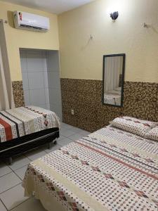 a hospital room with two beds and a mirror at Flat Crystal Park Porto das Dunas- Cristal park in Aquiraz