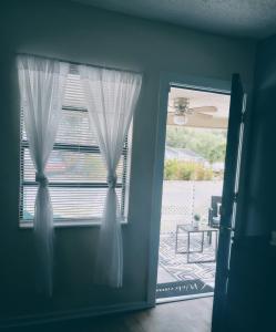 una puerta con una ventana con cortinas blancas en una habitación en cozy nice room en San Petersburgo