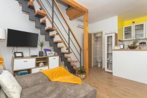 a living room with a couch and a staircase at Peaceful house in nature nearby National Park Krka in Brištane