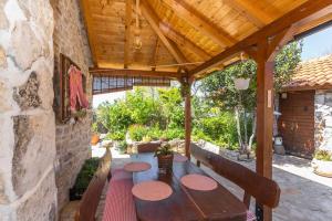 Peaceful house in nature nearby National Park Krka في Brištane: فناء في الهواء الطلق مع طاولة وكراسي خشبية