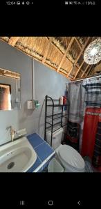 a bathroom with a toilet and a sink and a mirror at Luigi's Glamping in Bacalar