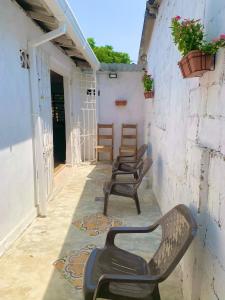 3 chaises assises sur une terrasse couverte dans un bâtiment dans l'établissement Casa Cairo, à Carthagène des Indes