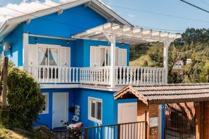 a blue house with a white balcony at Casa da bela Vista in Gramado