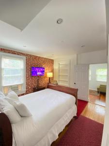 a bedroom with a white bed and a brick wall at Large DUPLEX Apt 2Bdrm 1Den-Metro in Washington, D.C.