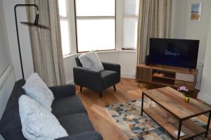 a living room with a couch and a chair and a television at Library House in Liverpool