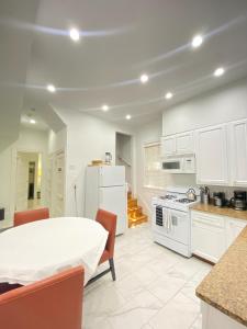 una cocina con armarios blancos y una mesa con sillas. en Large DUPLEX Apt 2Bdrm 1Den-Metro, en Washington