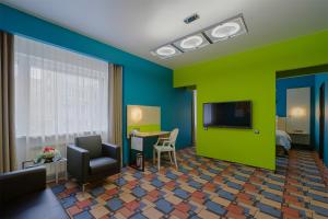 a living room filled with furniture and a tv at Dom Hotel NEO in Krasnoyarsk