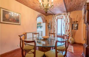 een eetkamer met een glazen tafel en stoelen bij Amazing Apartment In Molino Del Piano With House A Panoramic View in Molino del Piano