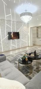 a living room with a couch and a chandelier at Luxury Apartment in the Center 6 in Tashkent