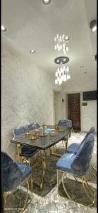 a dining room with a table and chairs and a chandelier at Luxury Apartment in the Center 6 in Tashkent
