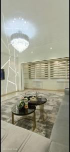 a living room with two tables and a chandelier at Luxury Apartment in the Center 6 in Tashkent