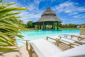 a swimming pool with chairs and a gazebo at Steps to Puntarena Beach Club and Restaurants - Amazing Location - Sleeps 9 in Boca de Río Hato
