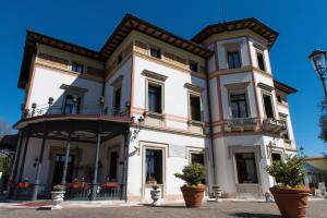 ein großes weißes Gebäude mit Balkonen und Topfpflanzen in der Unterkunft Hotel Villa Stucky in Mogliano Veneto