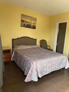1 dormitorio con 1 cama y 1 silla en Rancho Motel - Ontario Airport, en Ontario