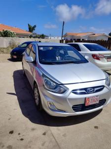 a white car parked in a parking lot at The Santy's in Oranjestad