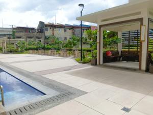 un patio con piscina y un edificio en The Celandine A Bonifacio Balintawak Condotel en Manila