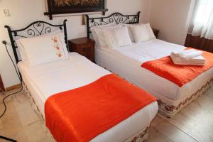 dwa łóżka siedzące obok siebie w pokoju w obiekcie alacati antik motel w mieście Çeşme