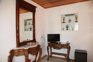 a room with a mirror and a table with a television at alacati antik motel in Cesme