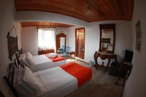 1 dormitorio con 2 camas, escritorio y TV en alacati antik motel, en Cesme