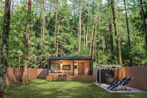 a tiny house in the woods with a backyard at Fuji Fumoto Forest Hotspring ふもとの森温泉 in Fujikawaguchiko