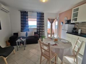 a kitchen and living room with a table and chairs at Apartment Punat 5378b in Punat
