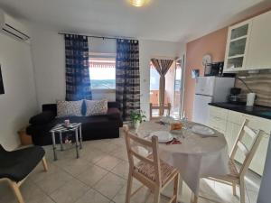 Una cocina y una sala de estar con mesa y sillas. en Apartment Punat 5378b, en Punat