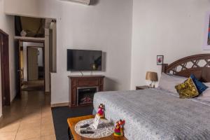 a bedroom with a bed with a television and a table at Don Paco's Country House in Copan Ruinas