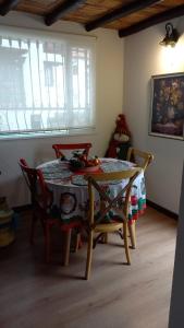 ein Esszimmer mit einem Tisch, Stühlen und einem Fenster in der Unterkunft Hostal La Cestería Pueblito Boyacense in Duitama