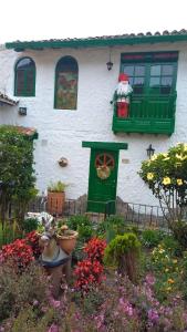 ein Haus mit einem Blumengarten davor in der Unterkunft Hostal La Cestería Pueblito Boyacense in Duitama