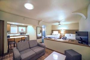a hotel room with a bed and a living room at Holiday Inn Hotel & Suites Chihuahua, an IHG Hotel in Chihuahua
