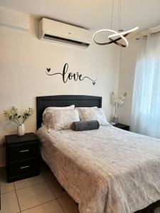 德古西加巴的住宿－Monoambiente Apart-Studio，卧室配有一张挂有爱情标志的床