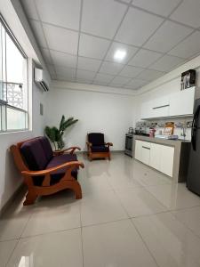 a living room with two chairs and a kitchen at Alojamiento increíble!! in Iquitos