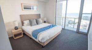 1 dormitorio con 1 cama y vistas al océano en Verve on Cotton Tree, en Maroochydore