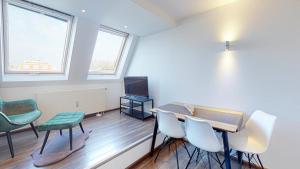 ein Zimmer mit Tisch und Stühlen und einem Fernseher in der Unterkunft Spacious 4 Bedroom Apartment near City Center in München
