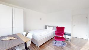 ein Schlafzimmer mit einem Bett und zwei roten Stühlen in der Unterkunft Spacious 4 Bedroom Apartment near City Center in München