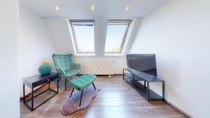 - un salon avec deux chaises et une télévision dans l'établissement Spacious 4 Bedroom Apartment near City Center, à Munich