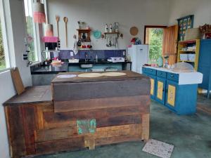 a kitchen with a wooden island in the middle at Casa com Vista para Montanhas - C Diamantina in Palmeiras