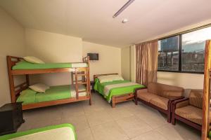 Habitación con 2 literas y sofá en Hotel Tungurahua en Baños
