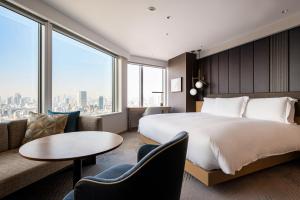 東京にあるストリングスホテル東京インターコンチネンタルの大きなベッドとソファが備わるホテルルームです。