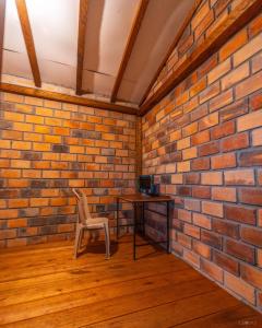 a brick walled room with a table and a chair at Finca Valentina in Valladolid