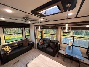 a living room in an rv with couches and a table at Temecula Hilltop View Glamping Next To Wineries in Temecula