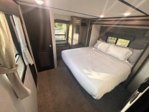 a bedroom with a white bed in an rv at Temecula Hilltop View Glamping Next To Wineries in Temecula