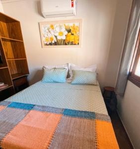 a bedroom with a bed with a colorful quilt at Recanto Vieira Praia do Estaleiro in Balneário Camboriú