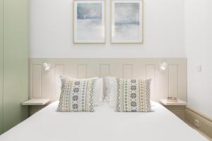 ポルトにあるOX Apartments B Artsの白いベッドと枕が2つある寝室
